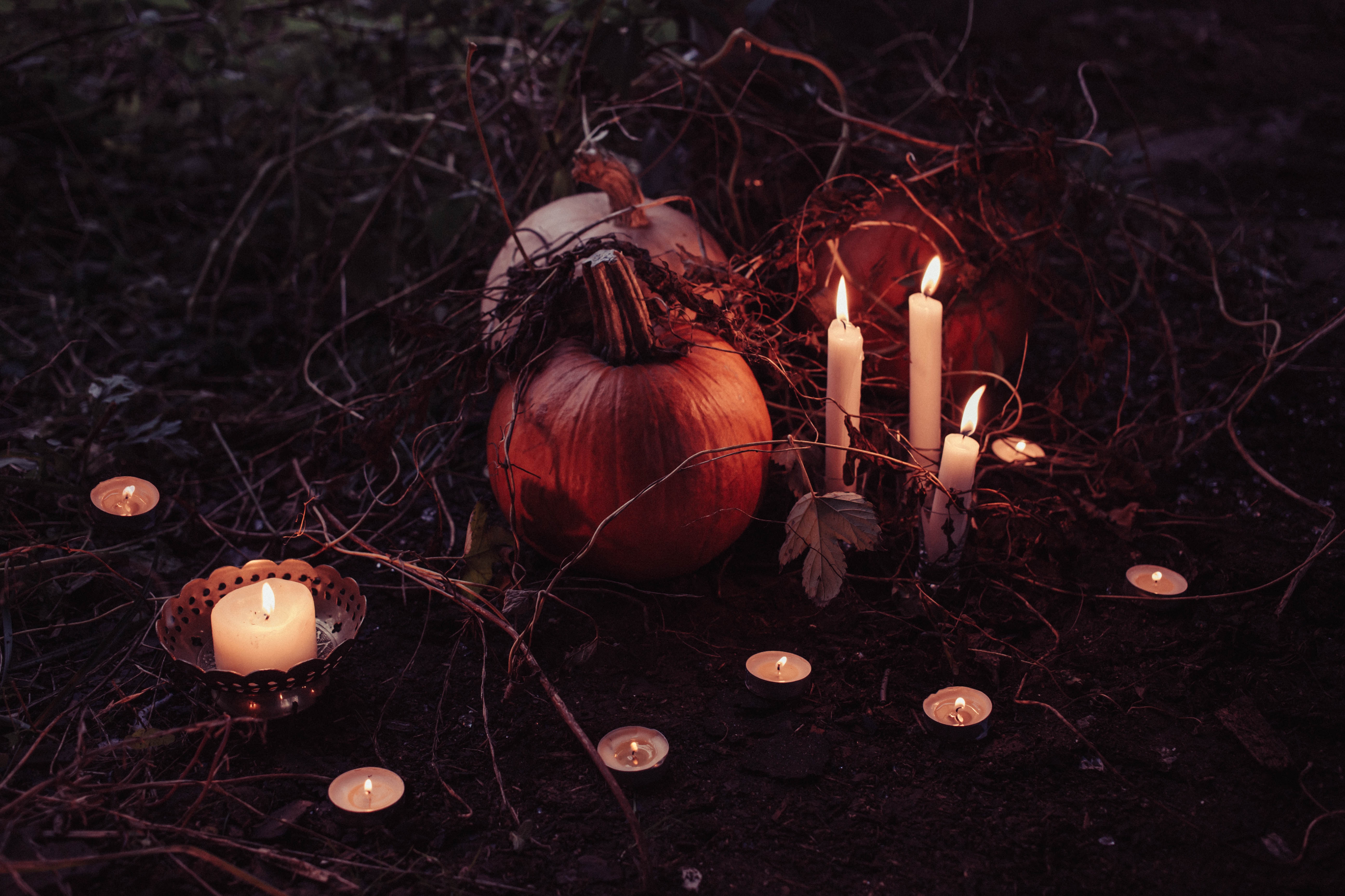 photo of pumpkin and partial skull surrounded by lit candles
